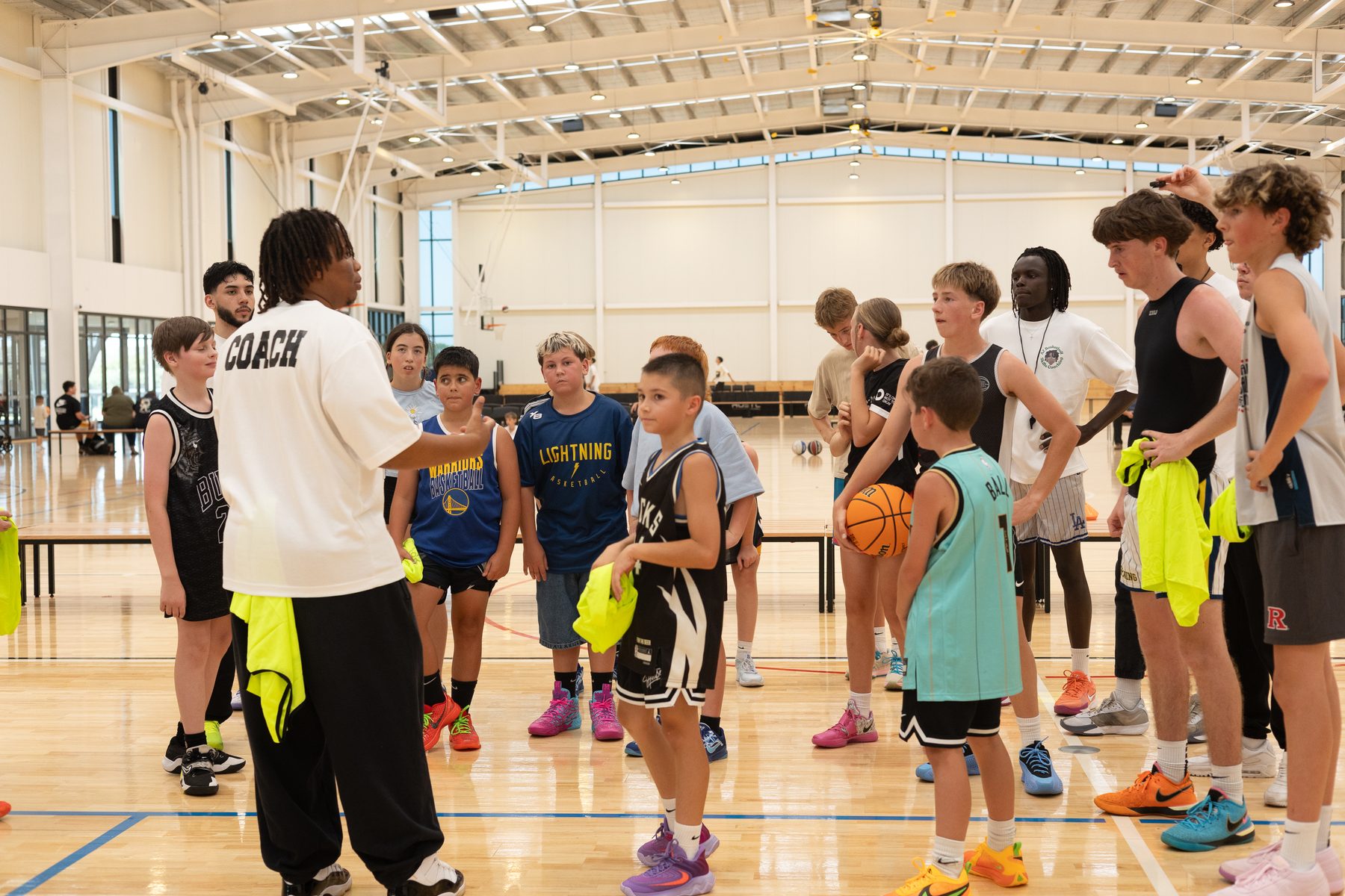 Coach instructing a group of young players in a huddle