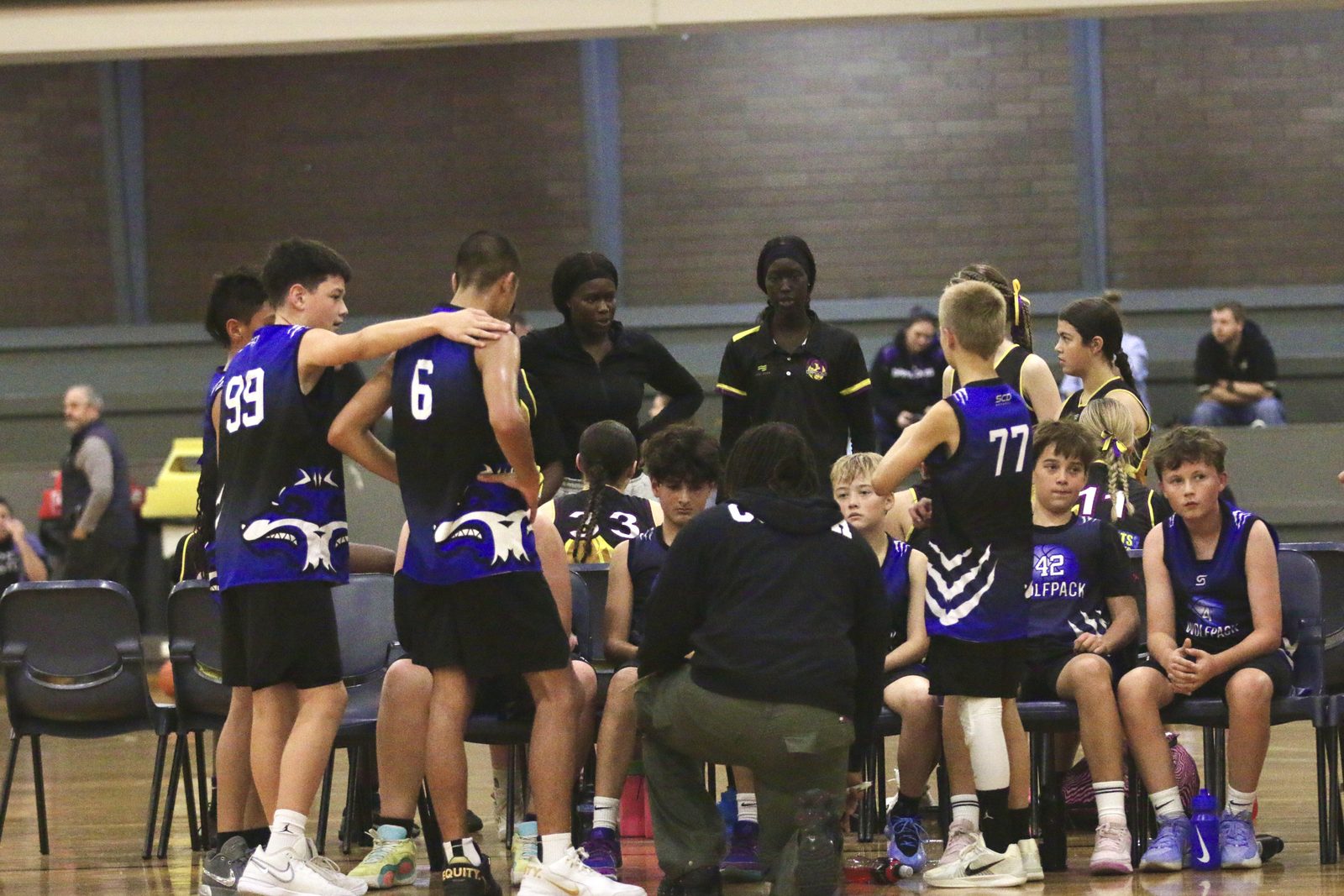 Youth team in a timeout huddle on the bench